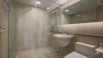 A modern bathroom with a glass-enclosed shower, a sink, and a toilet.