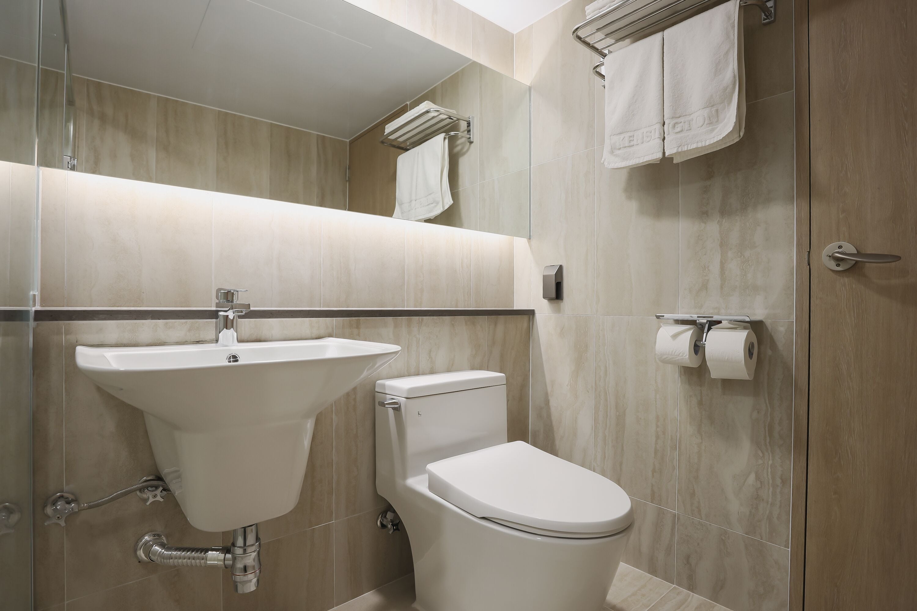 Une salle de bain moderne avec un lavabo, des toilettes et un porte-serviettes.