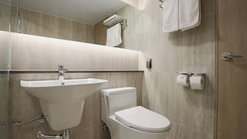 Une salle de bain moderne avec un lavabo, des toilettes et un porte-serviettes.