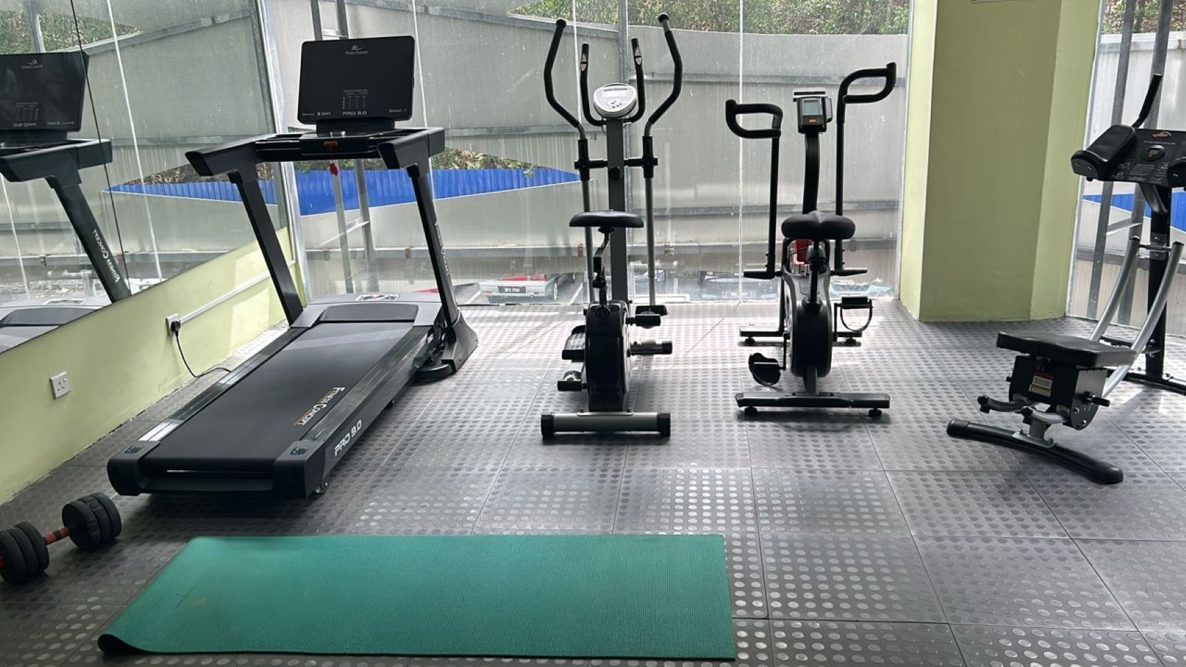 A gym with a treadmill, elliptical, and stationary bike.