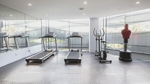 A gym with treadmills, a stationary bike, and a rowing machine.