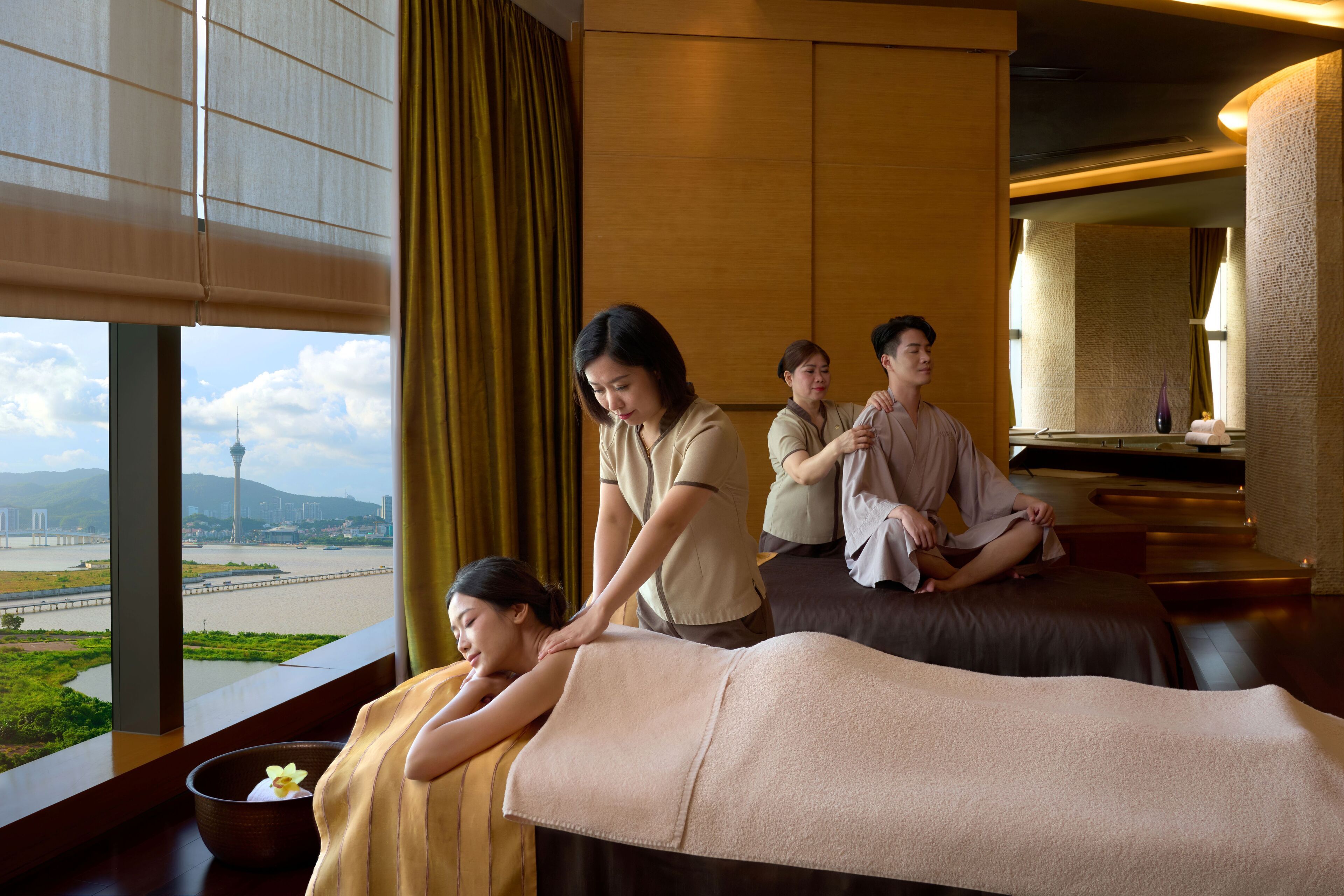 A massage therapy room with a view of a river and a tower.