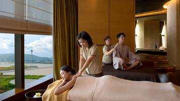 A massage therapy room with a view of a river and a tower.