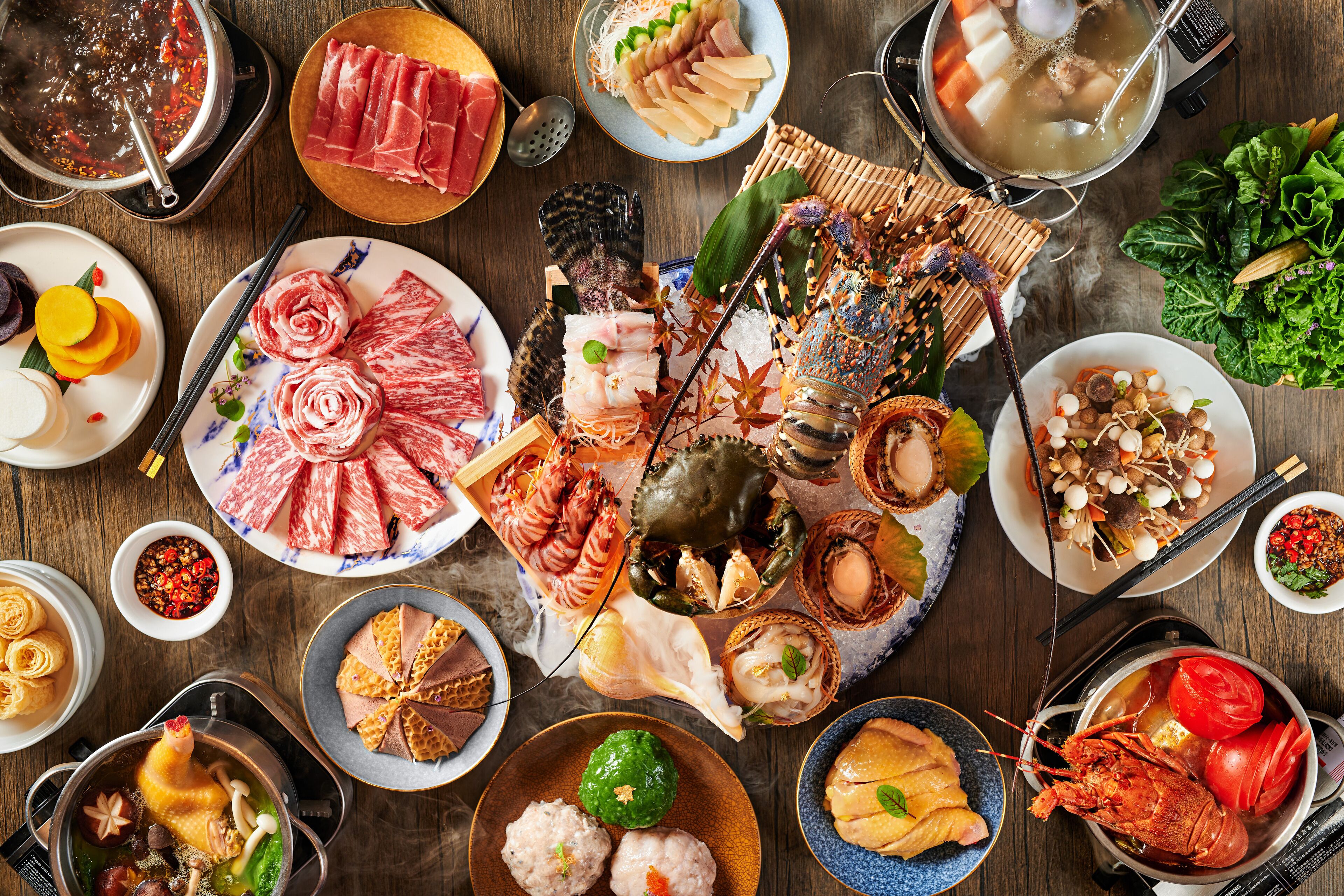 Variedad de platos que incluyen mariscos, verduras y carnes, dispuestos sobre una mesa de madera.