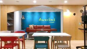 A modern room with a blue wall, a red sofa, and a white table. - Trust Hotel (Tainan)