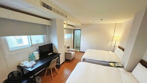 A hotel room with a bed, a desk with a computer, a chair, and a window. - Trust Hotel (Tainan)