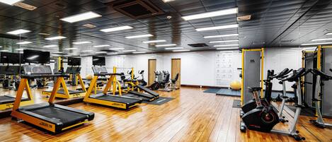 A gym with treadmills, weight machines, and exercise balls.