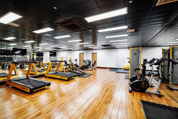 A gym with treadmills, weight machines, and exercise balls.