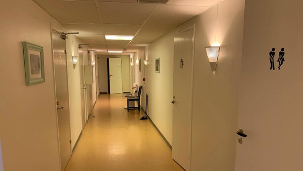 A hotel hallway with doors, framed pictures, and wall-mounted light fixtures. - Hällefors Vandrarhem & Kanotcenter - Hostel (Hallefors)