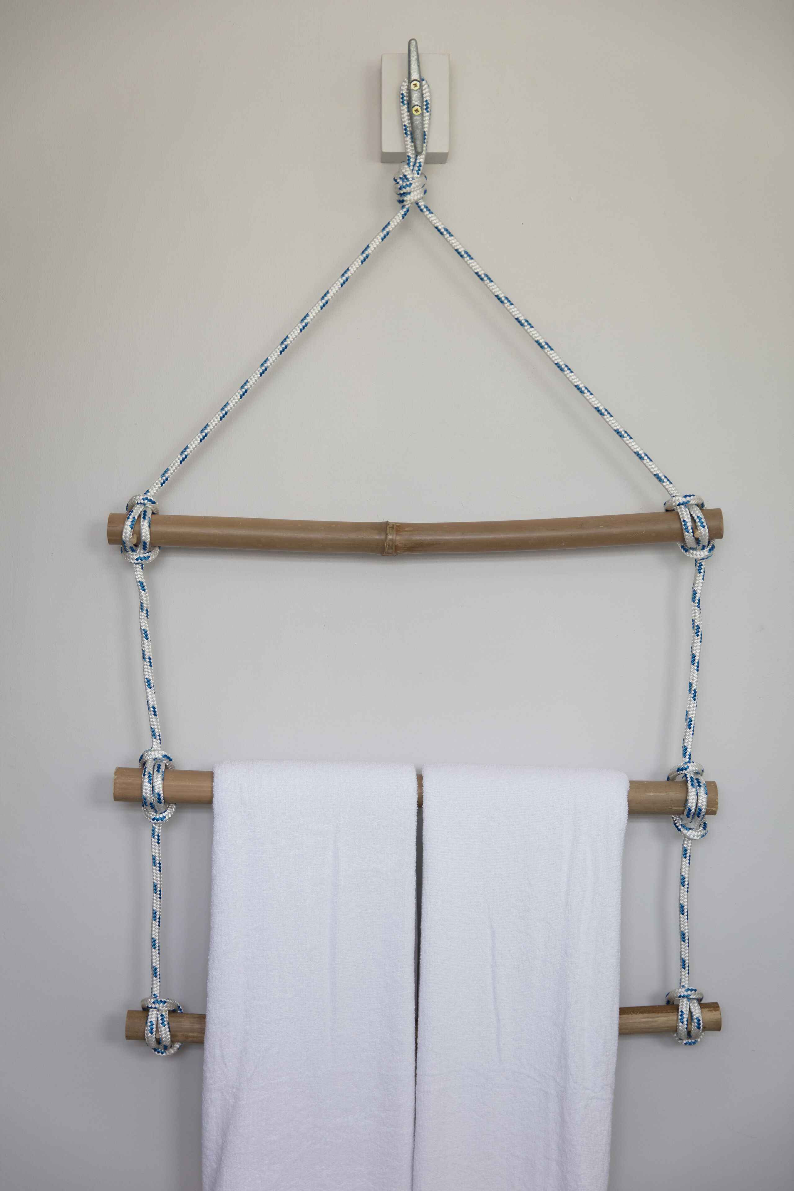 A towel rack with two white towels hanging from it.