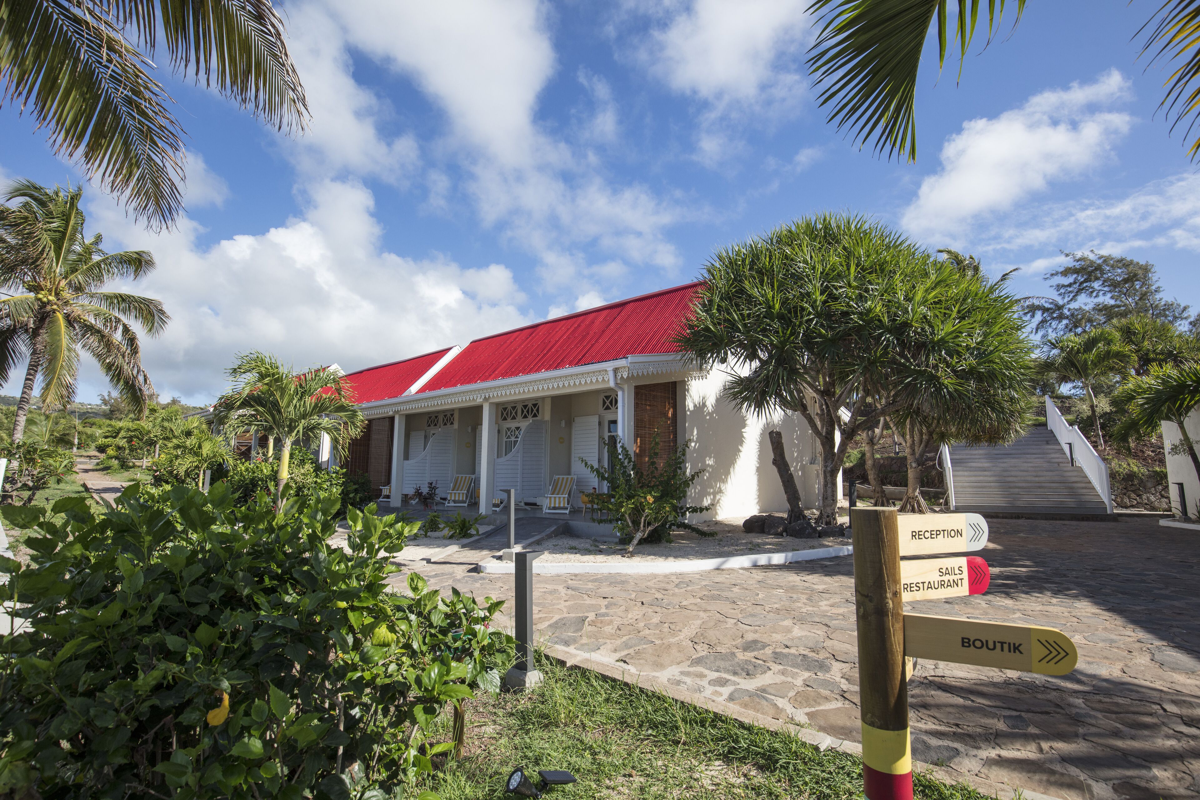 A building with a red roof, a reception area, and a sign pointing to the reception and a restaurant.