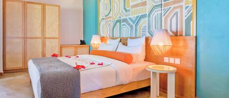 A bedroom with a bed, bedside lamps, a bedside table, and a wall with a geometric pattern.