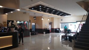 A hotel lobby with a reception desk, seating area, and a staircase. - Hotel Sogo Buendia (Pasay)