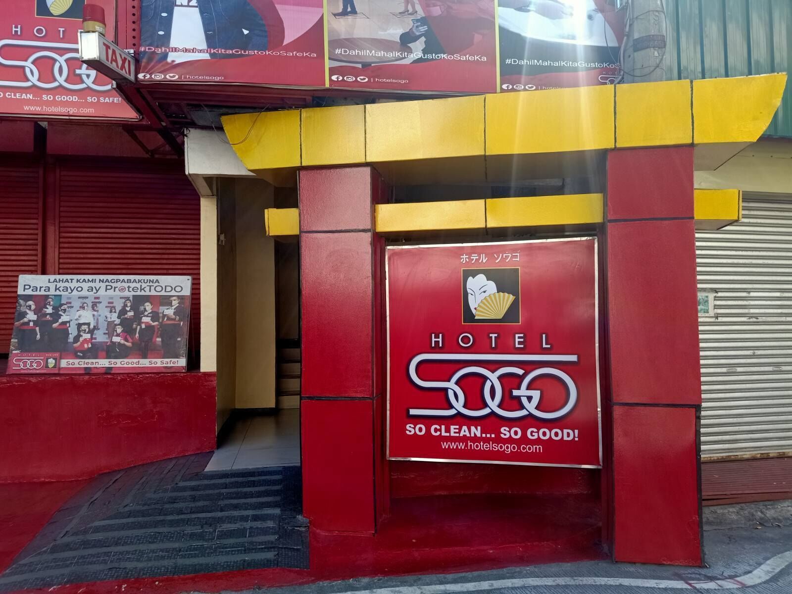 L’entrée d’un hôtel avec une façade rouge et jaune, une enseigne indiquant « HÔTEL 500 » et un slogan : « TELLEMENT PROPRE… TELLEMENT BIEN ! »