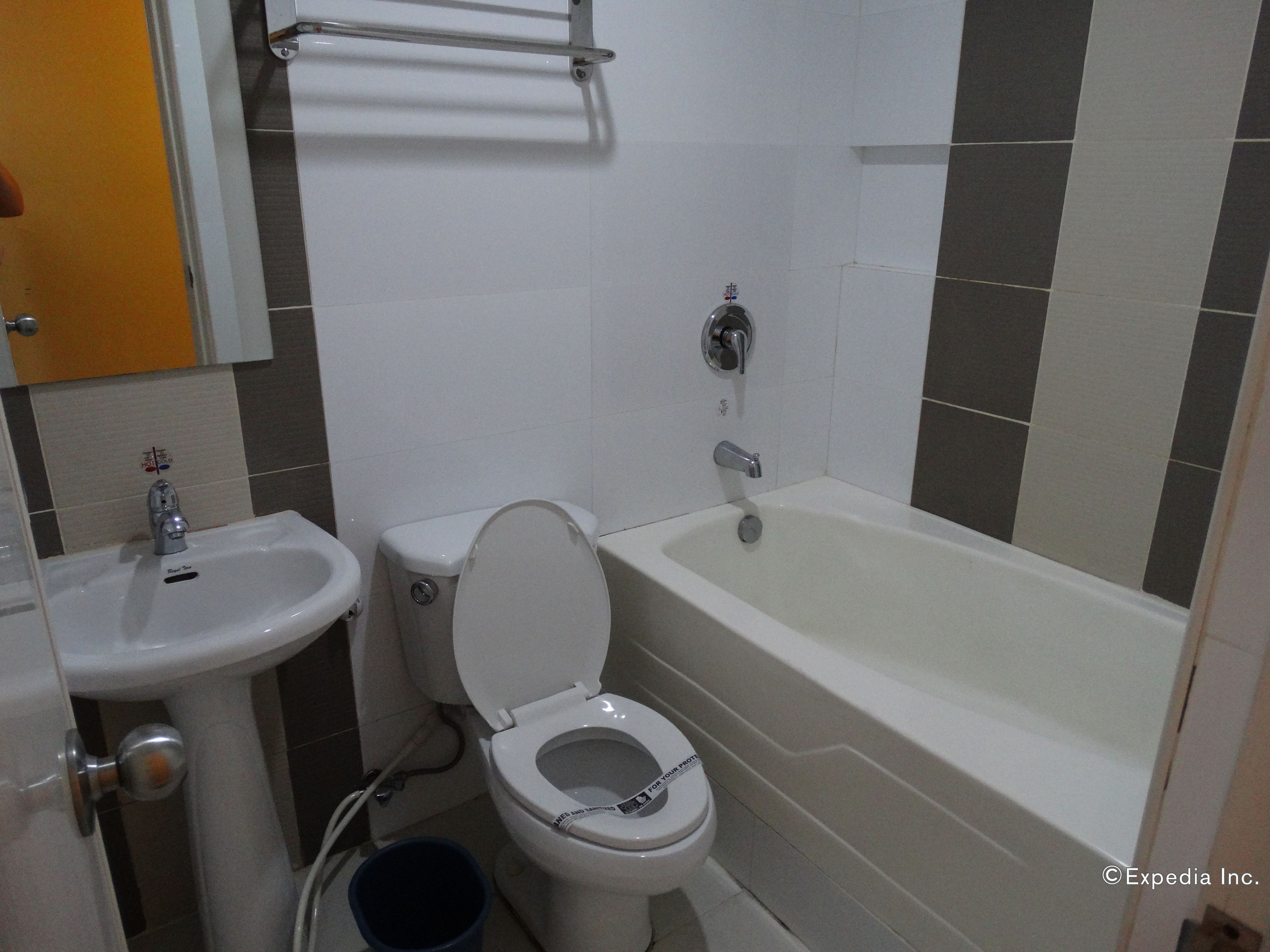 A bathroom with a toilet, sink, and bathtub.