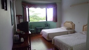 A room with two beds, a desk, a chair, and a television. - Hotel Hung Hung (Kuching)