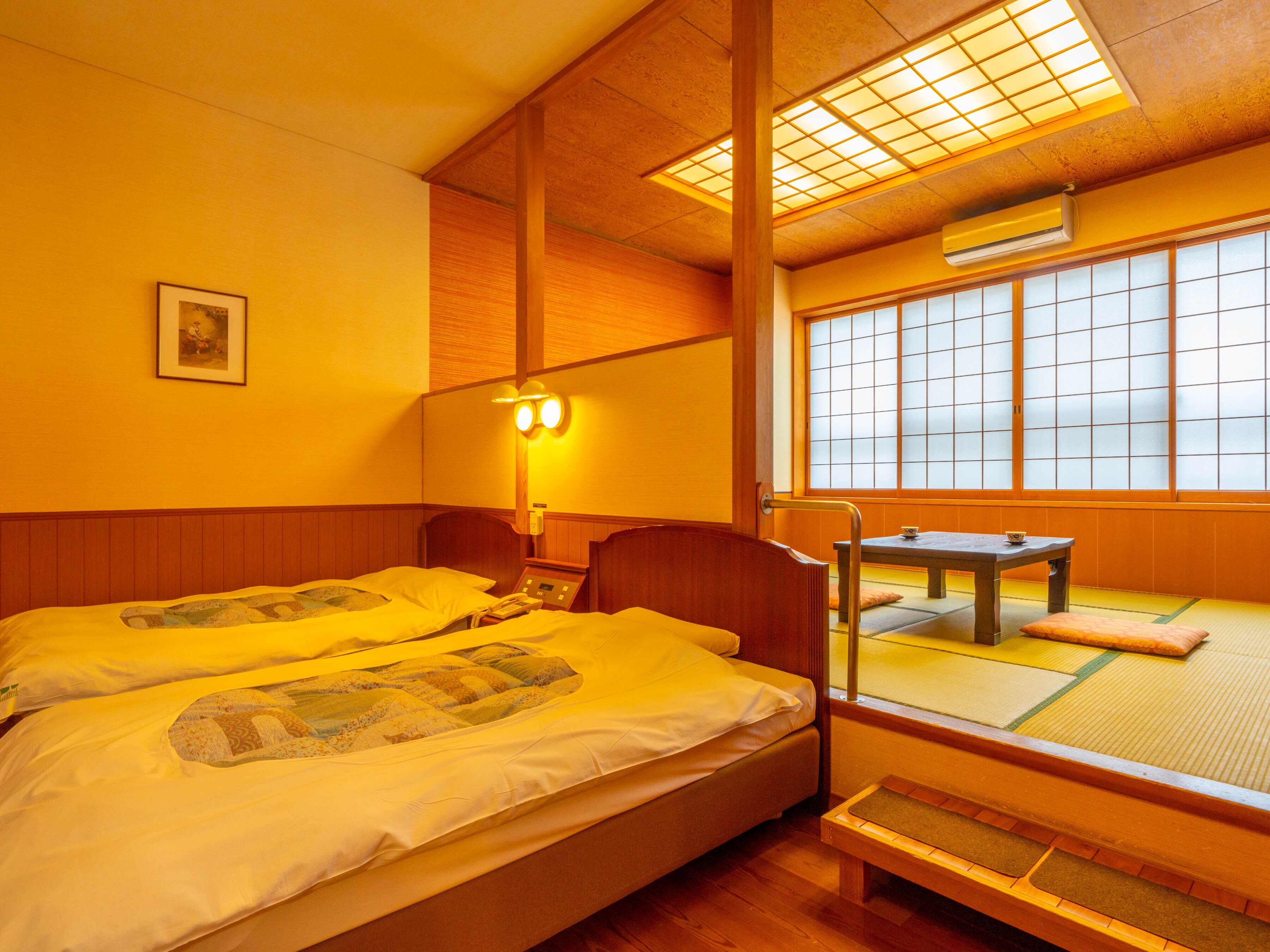 A traditional Japanese-style room with two beds, a tatami mat area, and a shoji screen window.