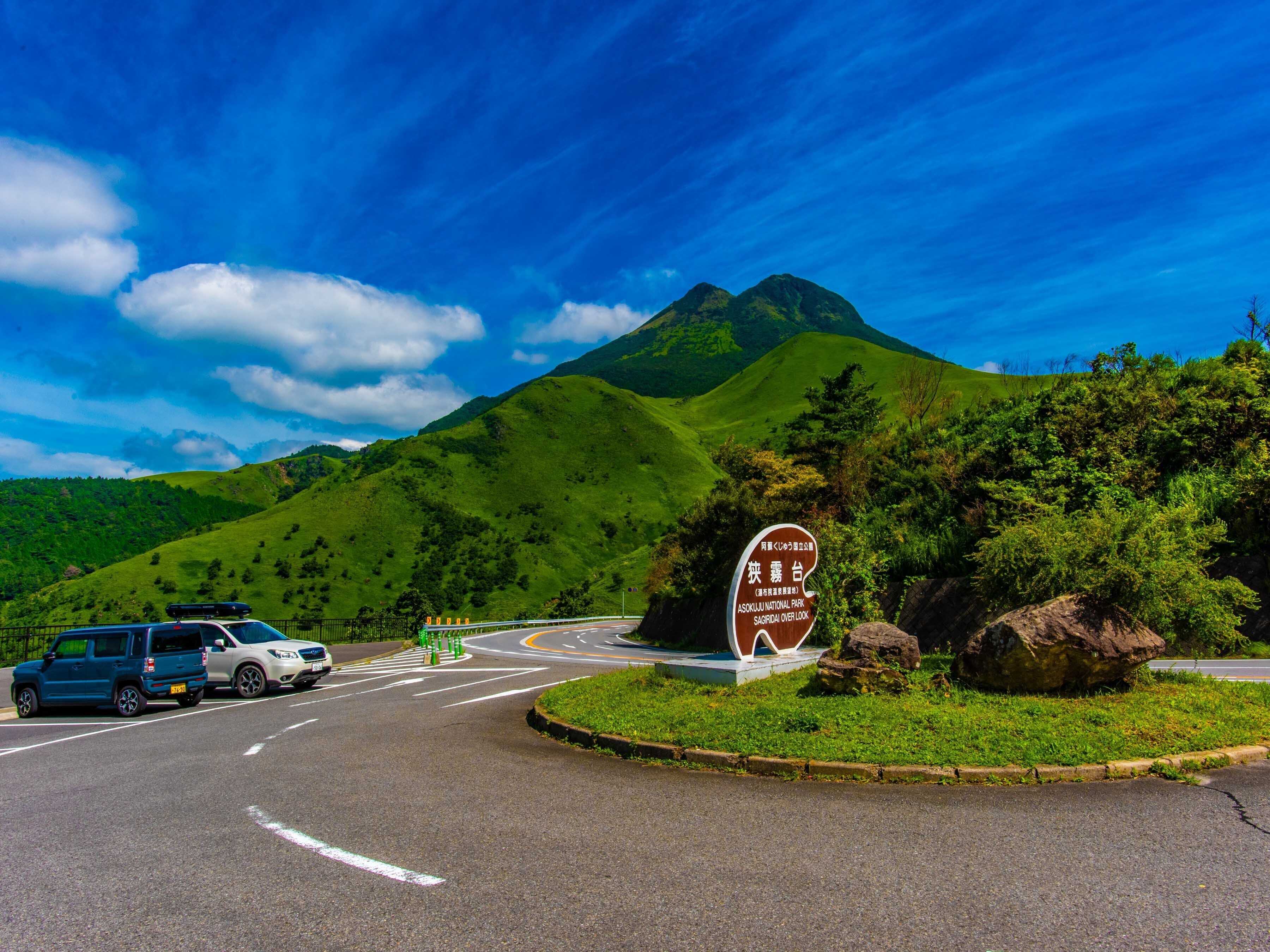 A road sign for Asahikawa National Park with a mountain in the background.