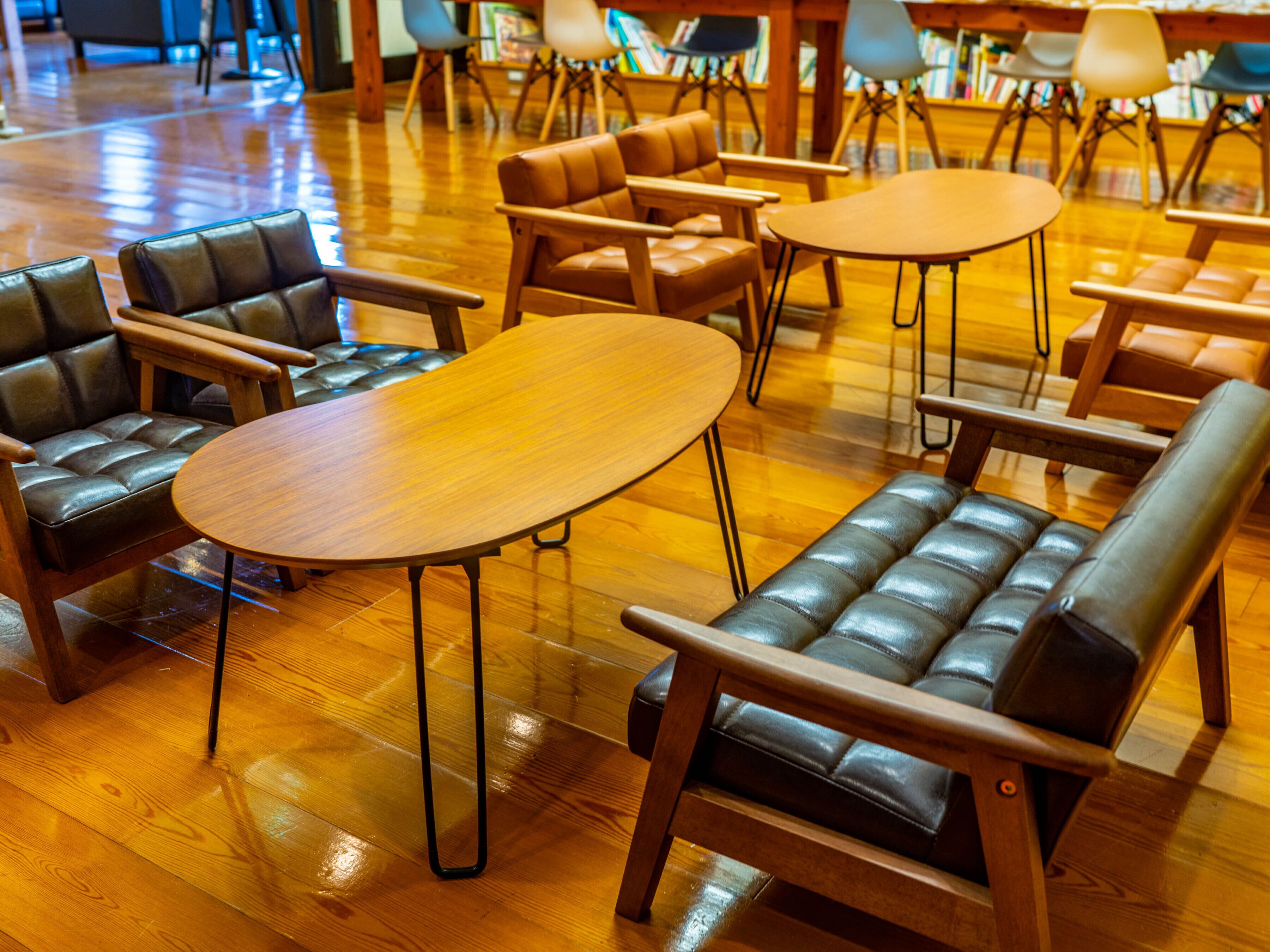 Una biblioteca moderna con sofás de cuero y mesas de madera.