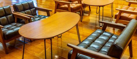 Una biblioteca moderna con sofás de cuero y mesas de madera.