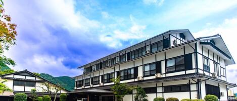 A modern building with a traditional architectural style, featuring a two-story structure with a flat roof and a covered entrance.