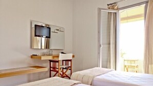 Hotelkamer met twee bedden, een bureau met stoel, een aan de muur bevestigde televisie en een balkon met gordijnen.