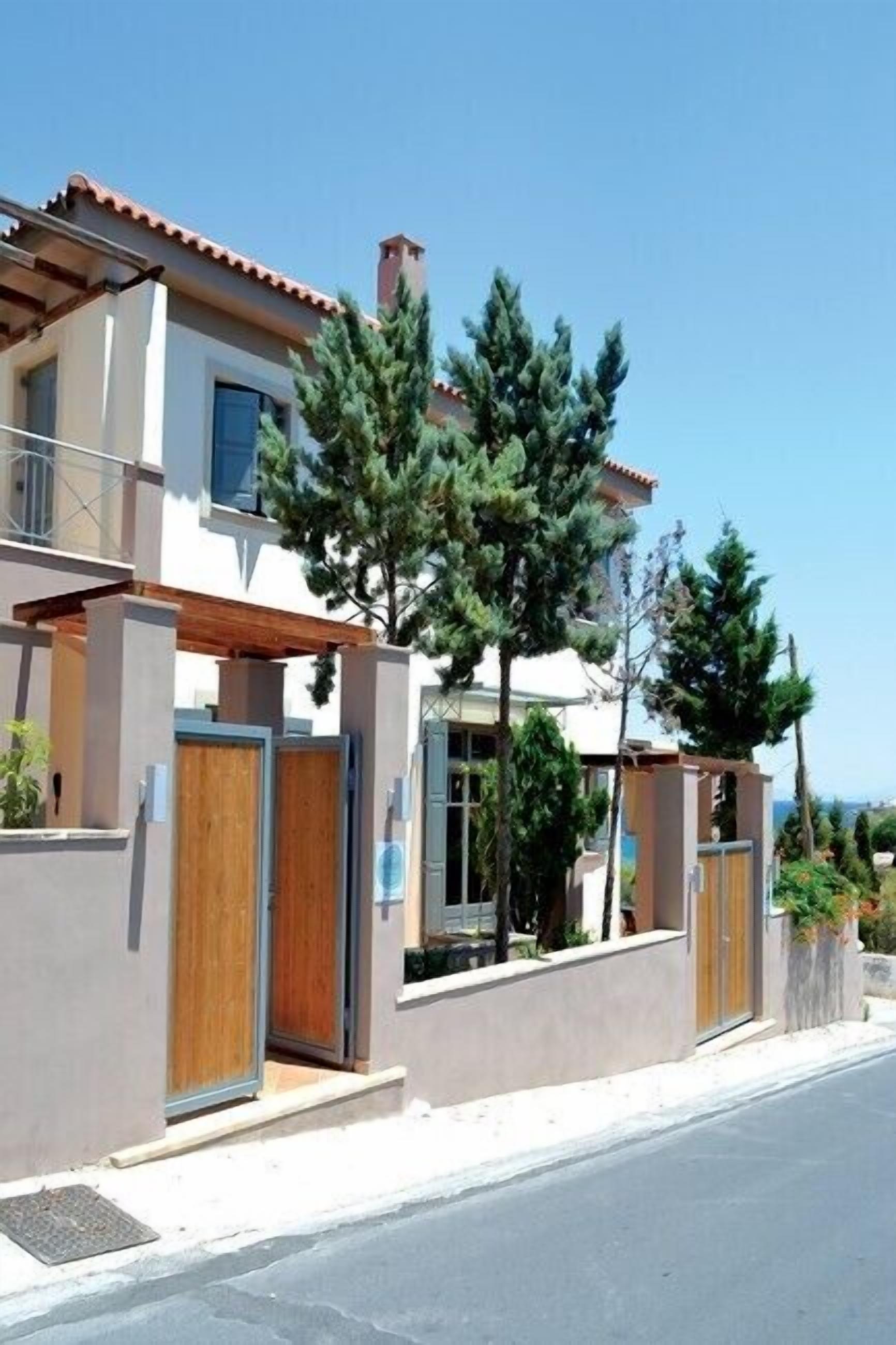 A modern two-story house with a wooden door and a balcony.