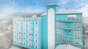 A turquoise building with the sign "ROWNE GARDEN" and multiple balconies with white railings. - Crowne Garden Hotel (Cebu City)