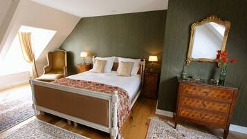 A bedroom with a bed, a dresser, a mirror, and a chair.