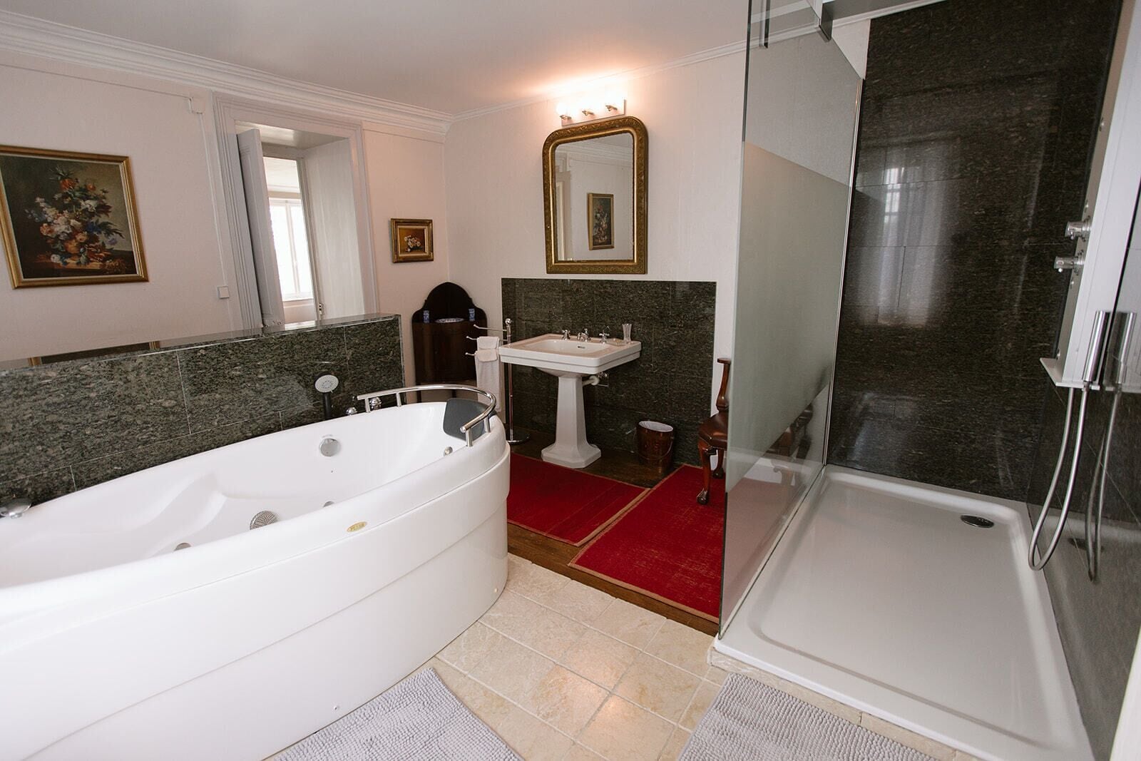 Une salle de bain avec une baignoire, un lavabo, une douche et un miroir.