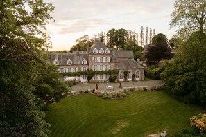 A large, historic building with multiple windows and a well-maintained lawn. - Château La Rametière (Le Parc)