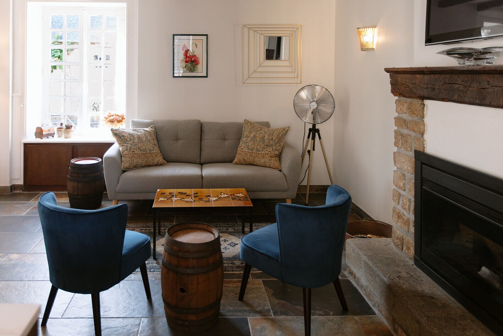 A living room with a sofa, two chairs, a coffee table, a fireplace, and a television.