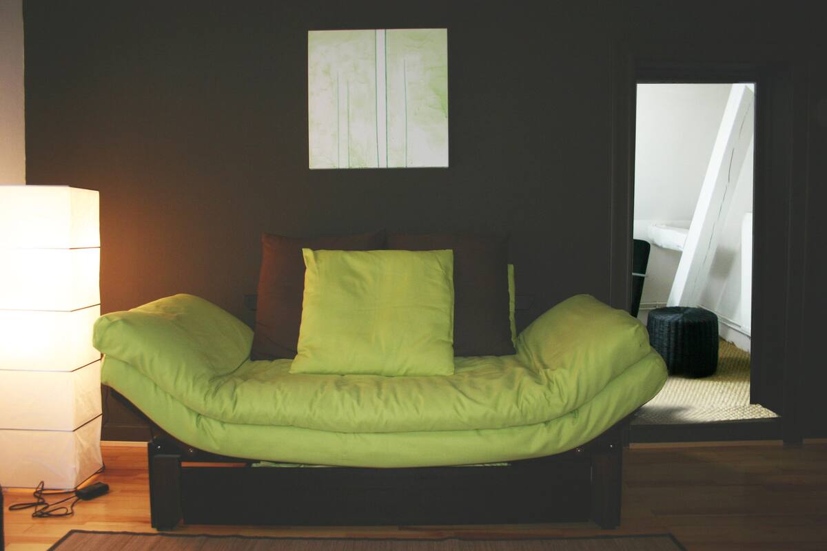 Une pièce avec un lit, une lampe et une fenêtre.