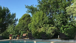 A clear blue pool with lounge chairs and a pergola. - La Mandarine (Piolenc)