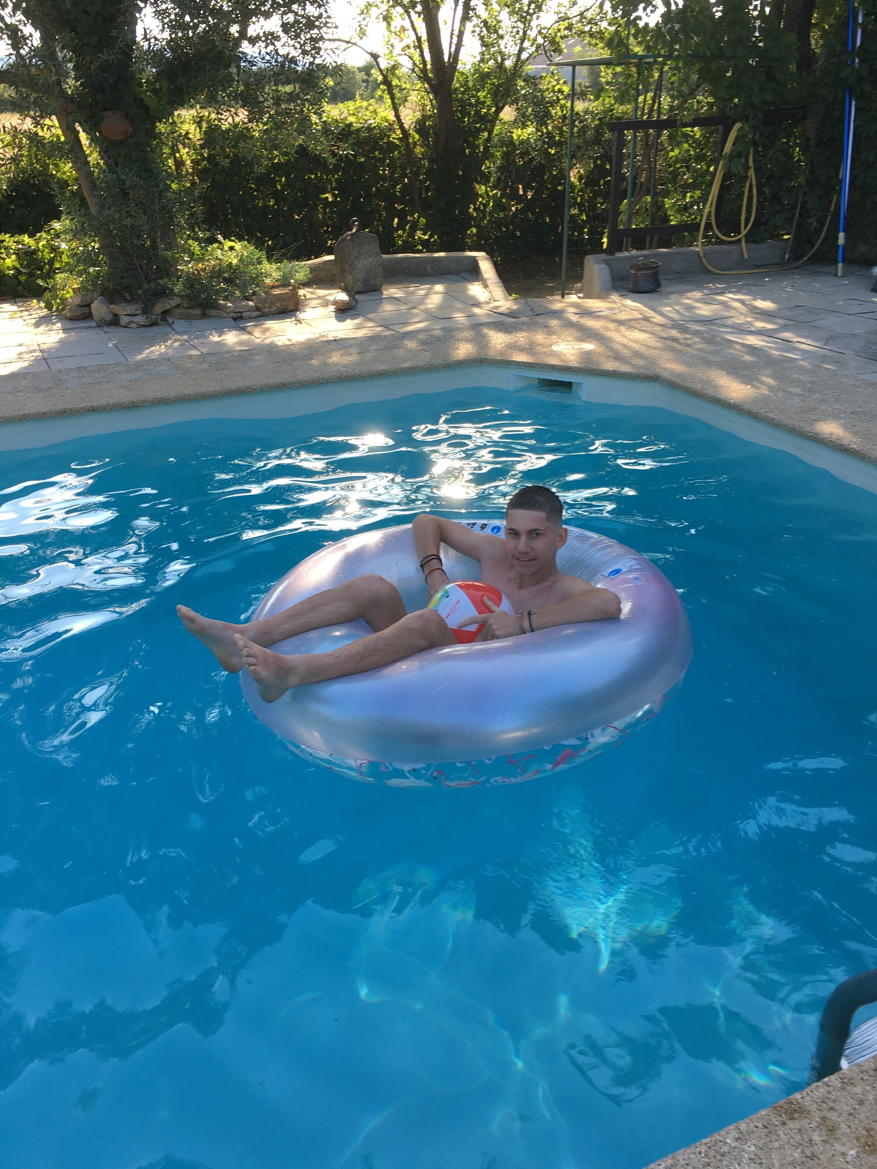 Uma pessoa boiando em um círculo inflável em uma piscina.