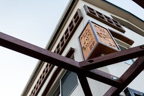 A clock on a building with a wooden frame and a white wall. - At Inn (Yufu)