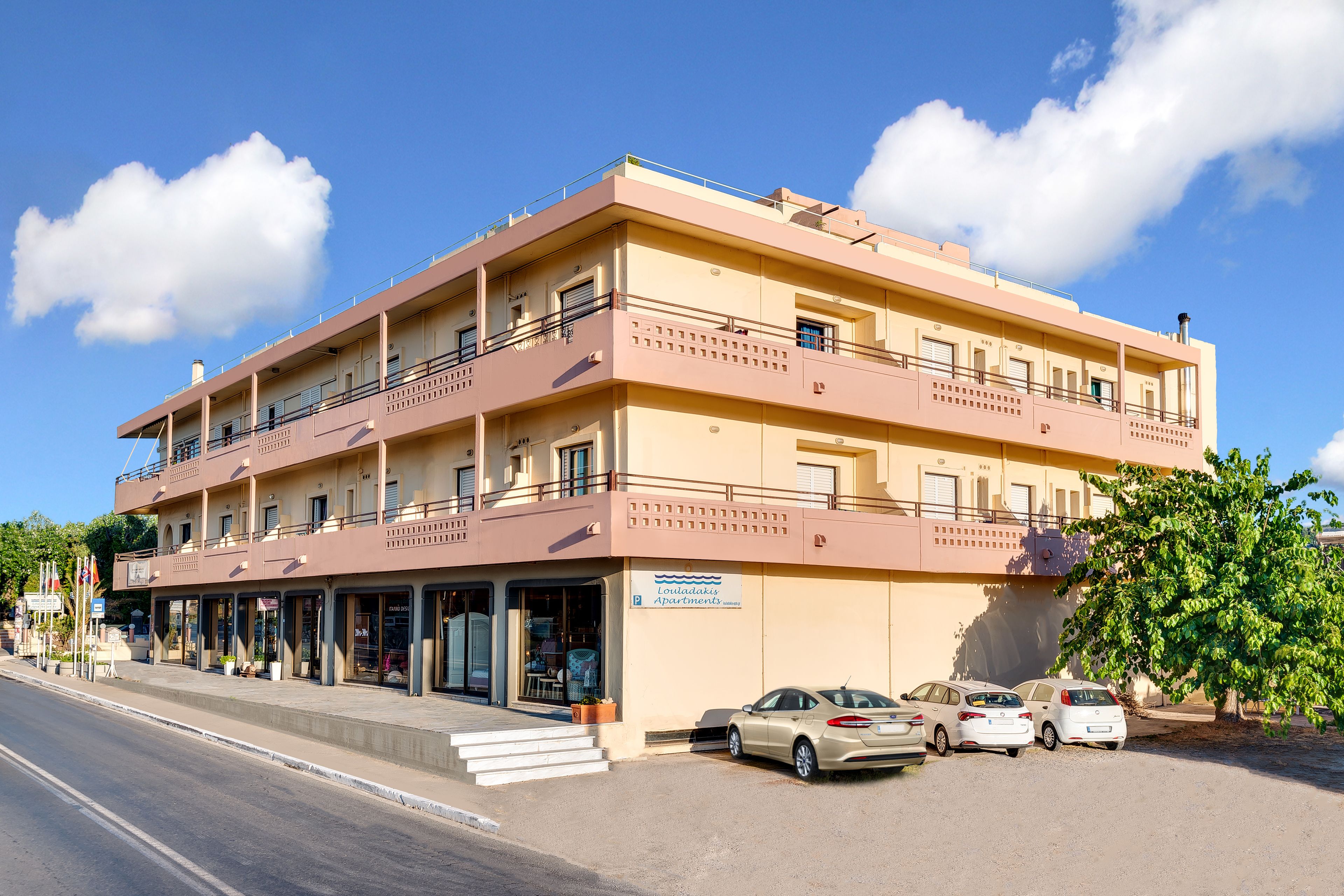 Un hôtel à plusieurs étages, doté de balcons, d’un parking et d’une enseigne indiquant qu’il s’agit d’un hôtel.
