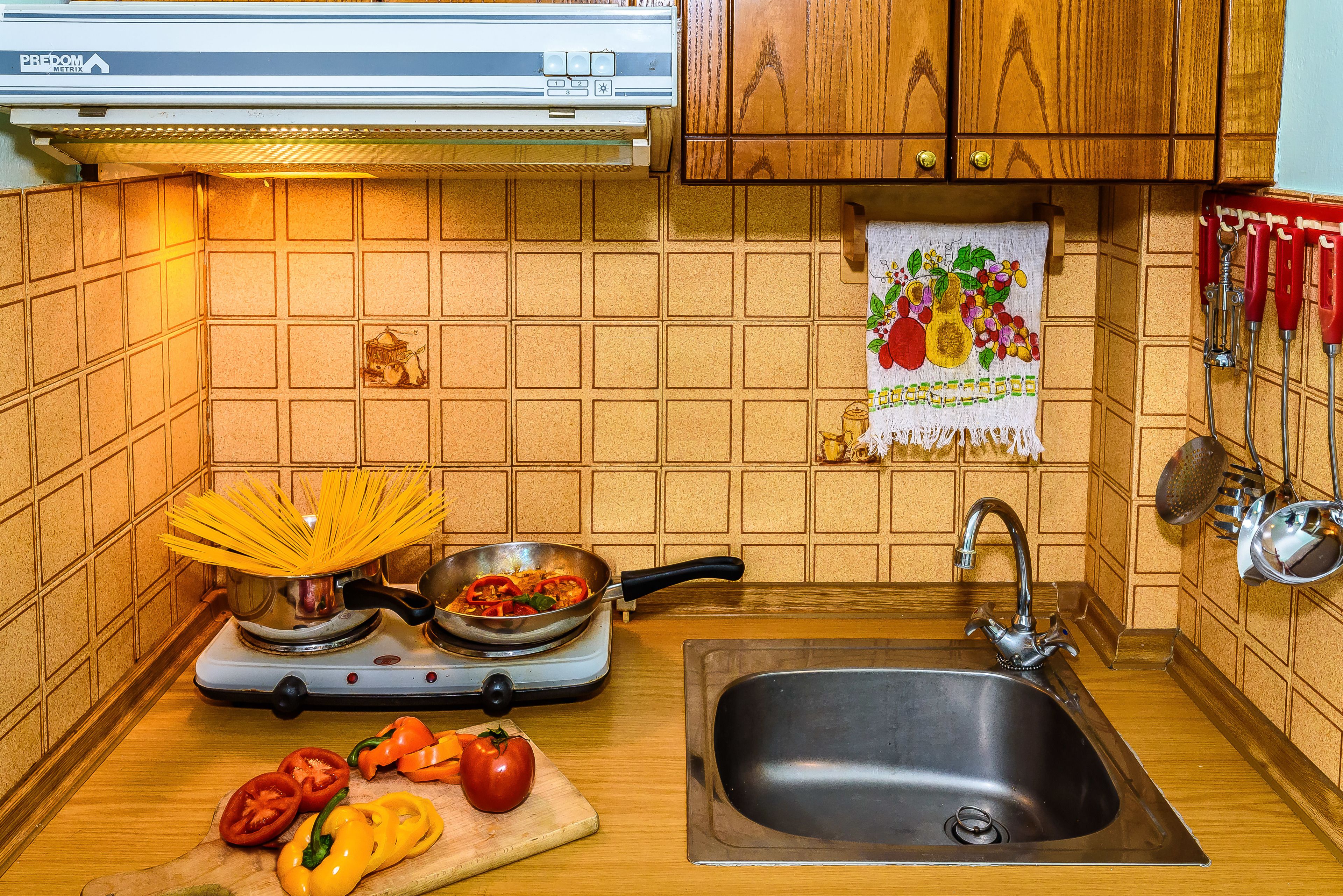Une cuisine équipée d’une cuisinière, d’un évier et de meubles de rangement en bois.