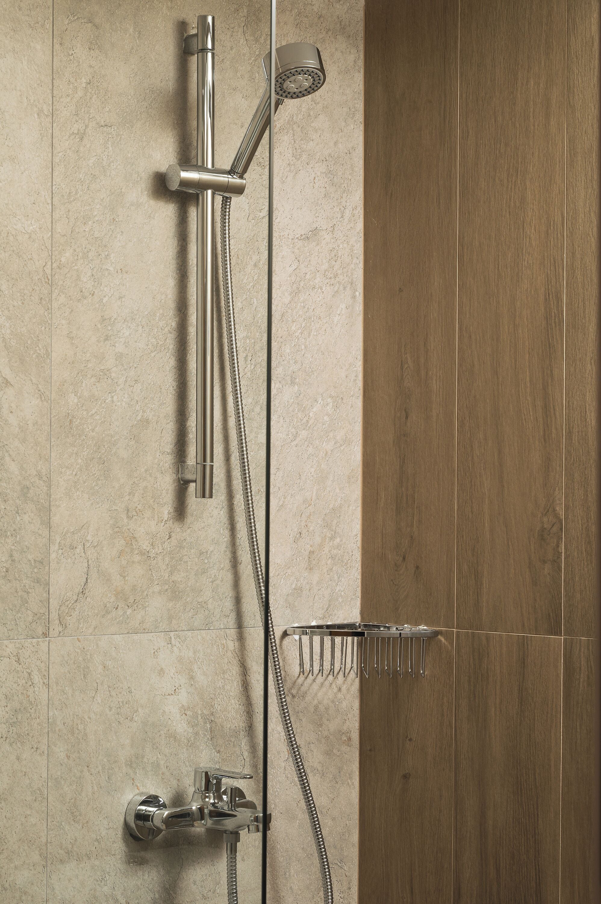 A shower with a handheld showerhead and a wall-mounted faucet.