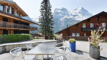 Eine Holzhütte mit einem Balkon mit Blick auf einen verschneiten Berg.