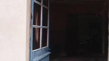 Una habitación con puerta de madera y ventana con cortinas.