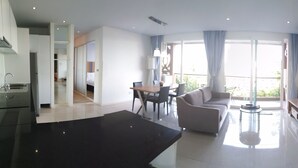 Ein modernes Wohnzimmer mit Sofa, Esstisch und Fernseher.