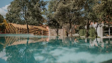 Una piscina al aire libre de temporada, sombrillas