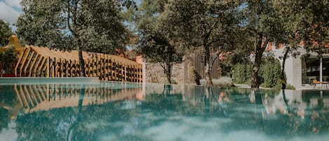 Una piscina al aire libre de temporada, sombrillas