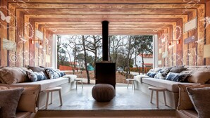 A cozy living room with a fireplace, two sofas, and a view of the outdoors.