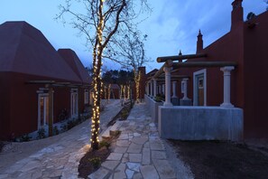 Stroll along the serene pathway, lined with traditional buildings and string lights, offering a warm welcome.