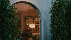 A cozy interior with a round table, a cushioned bench, and a lamp.