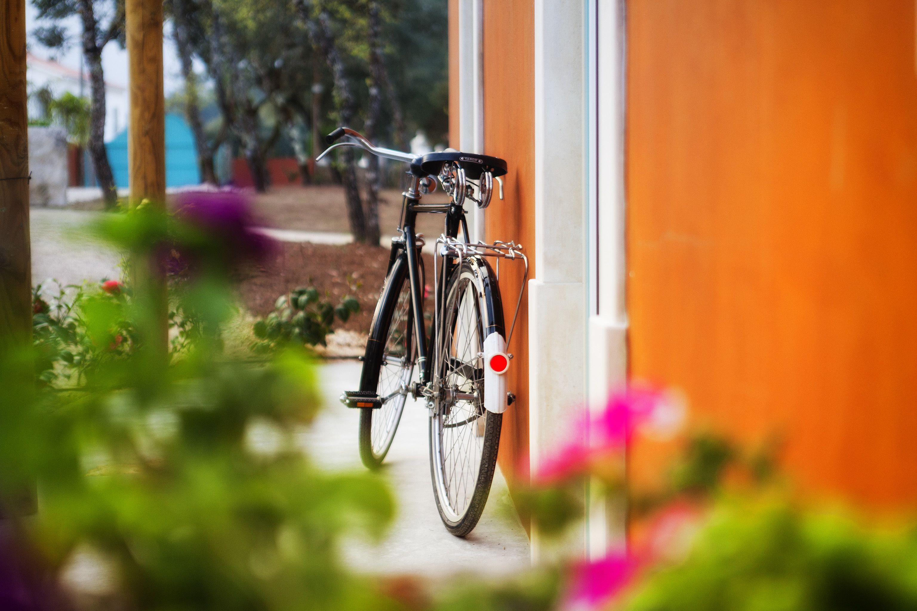 A bicycle parked against a building with a door.