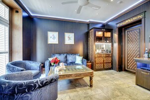 A modern living room with a sofa, armchairs, a coffee table, and a decorative cabinet.