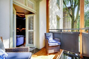 A balcony with wicker furniture, a sliding door, and a view of the outside.